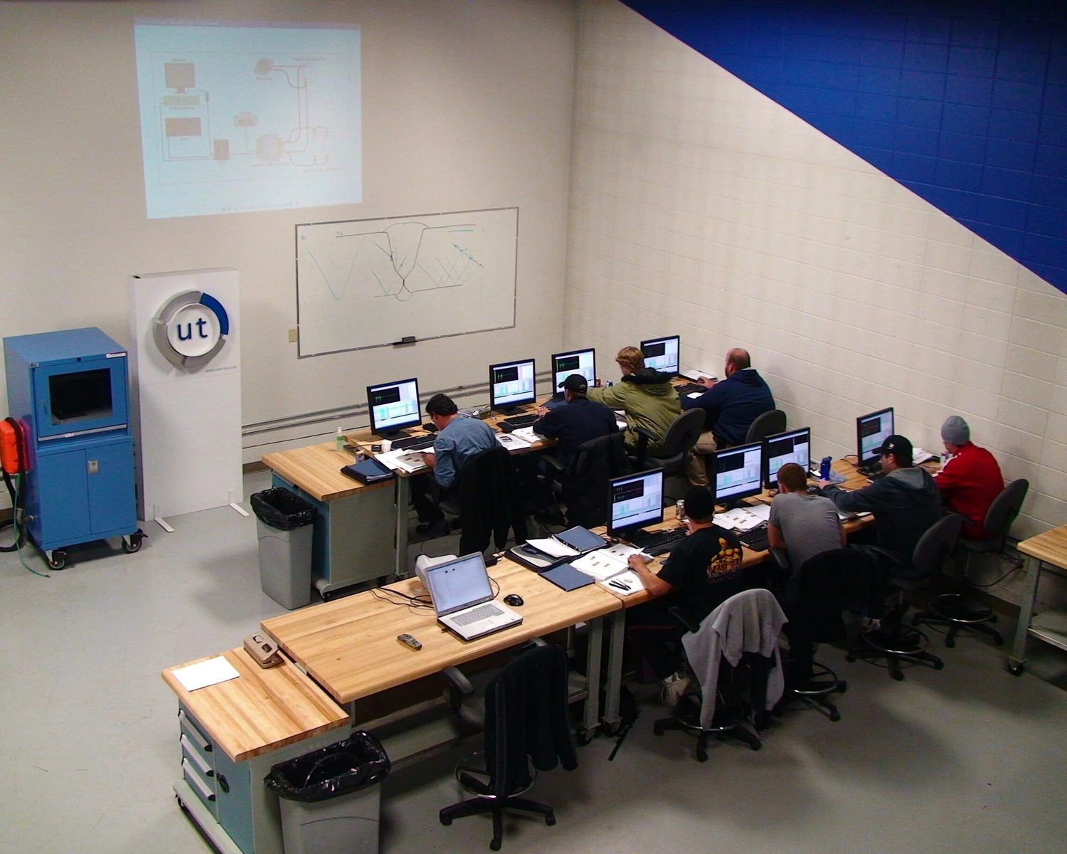 Technicians at inspection-data workstations in a training room